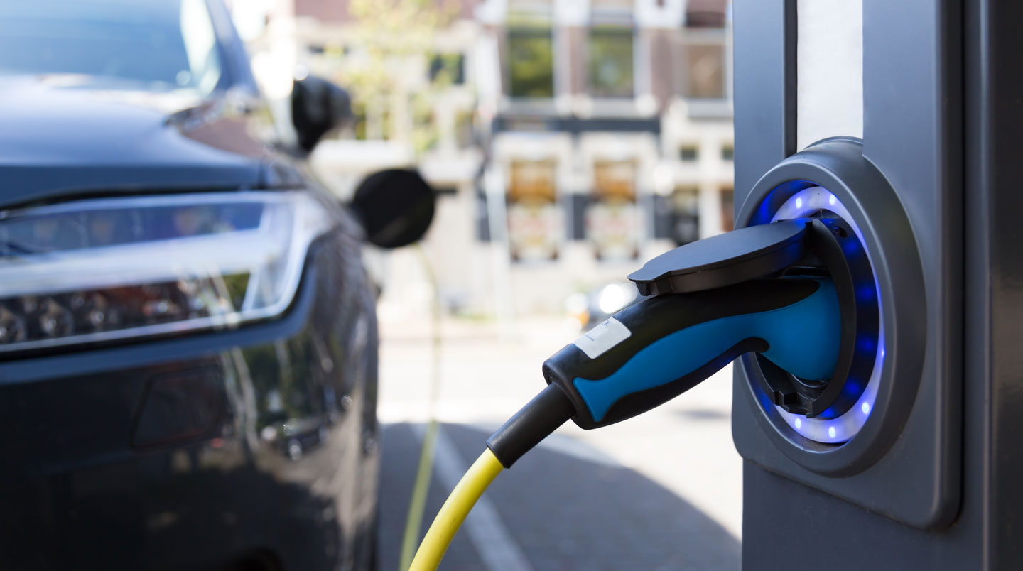 Voiture électrique Renault Mégane E-Tech bleue en charge sur borne publique urbaine française, affichage indiquant puissance 7 kW et progression 42%, câble Type 2 branché